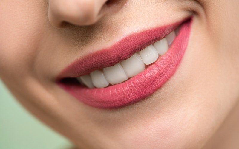 woman with red lipstick and white teeth smiling